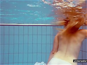 lovely red-haired plays bare underwater